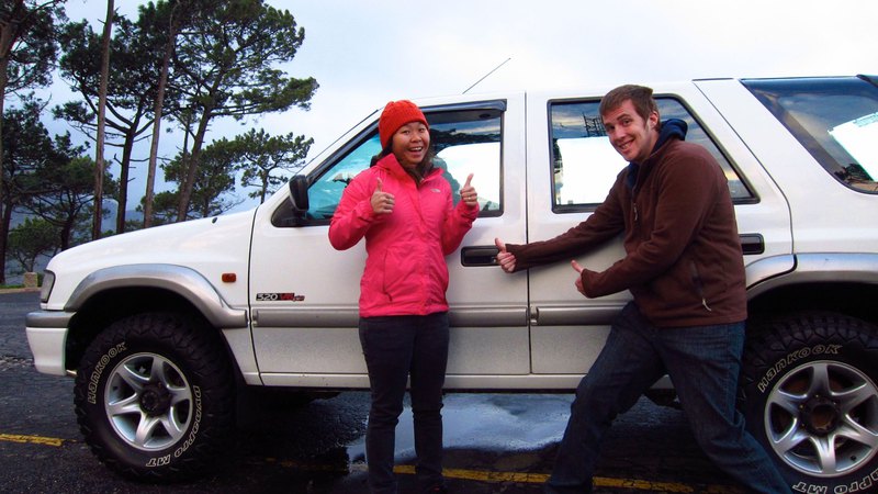 couple in front of an offroad vehicle